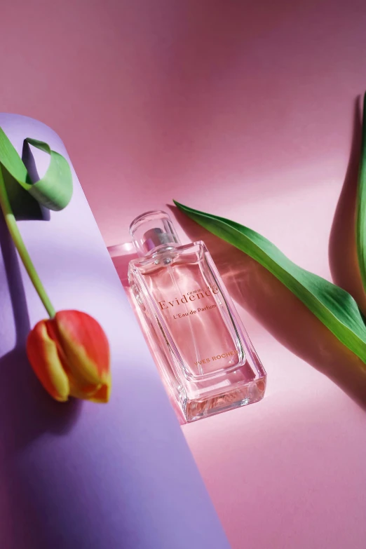 a bottle of perfume sitting next to some plant stems