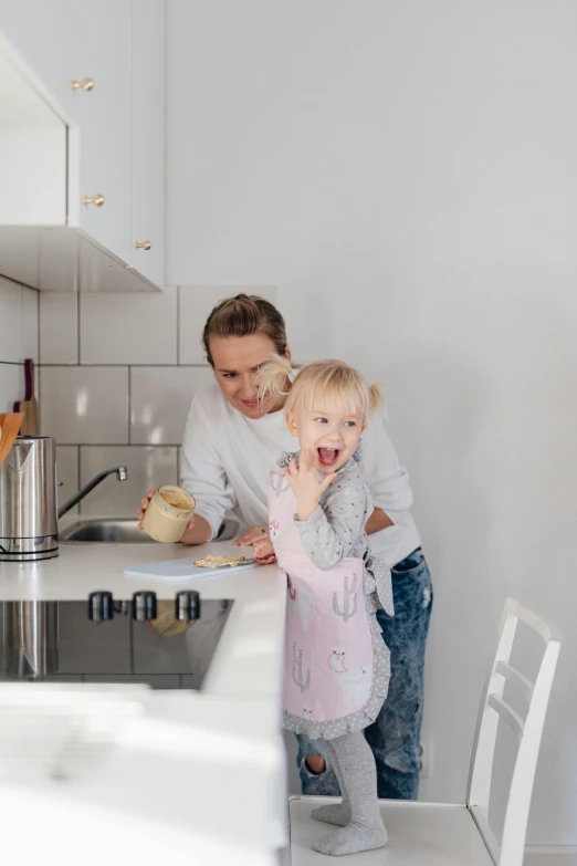 the woman and child are baking in the kitchen