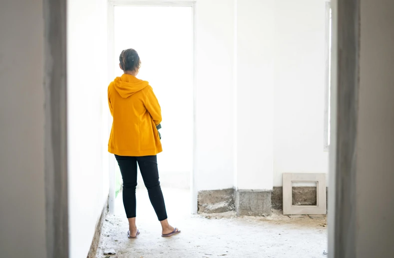 woman standing in an empty room with walls torn down