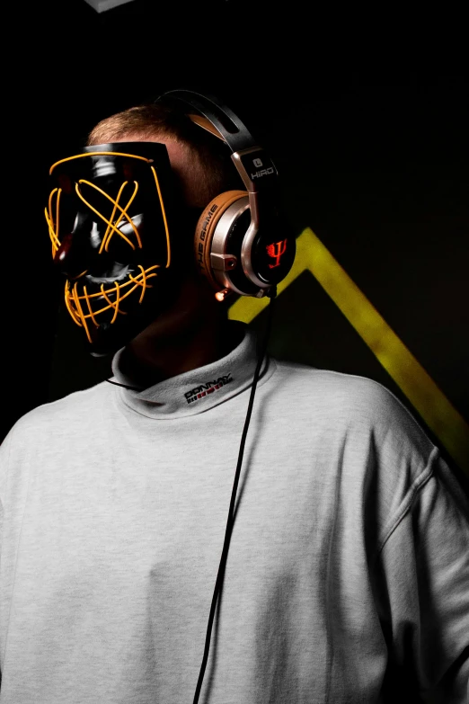 the man is wearing a neon mask and earphones