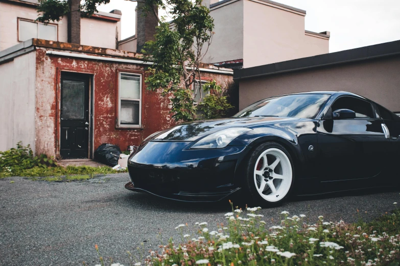 a very nice looking black car parked by a red building