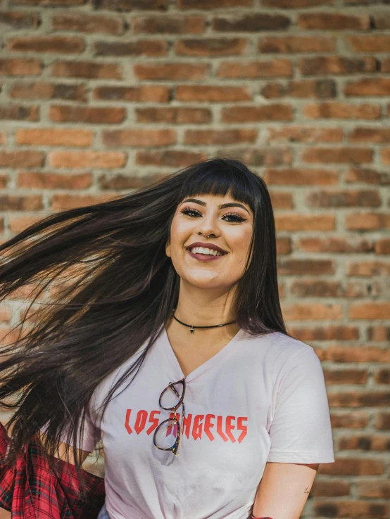 a smiling woman with long, hair in a bun outside