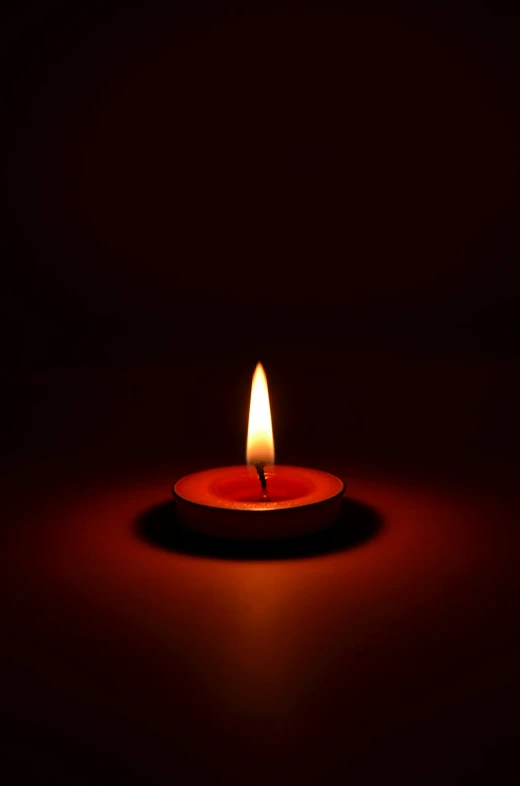 a red lit candle on a black background