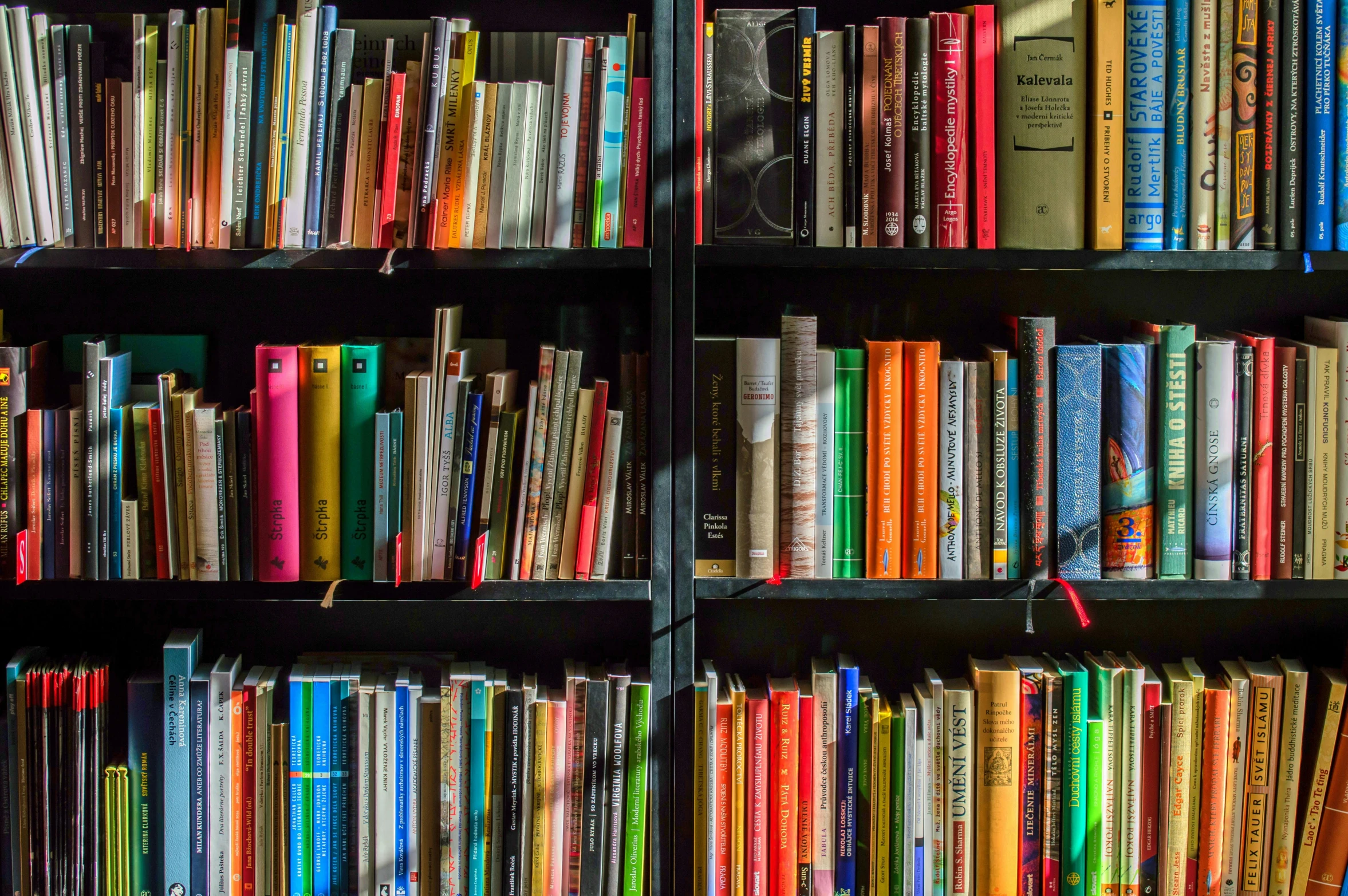 many books are sitting on shelves with some colored paper