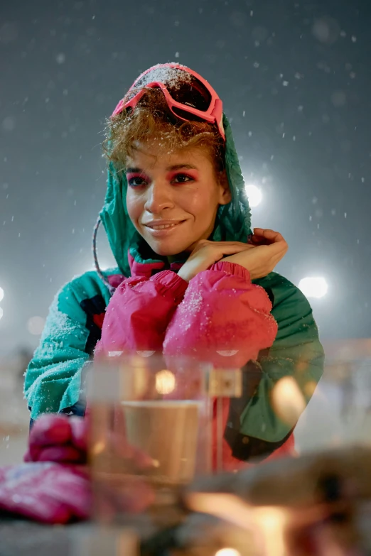 a young person sitting at a table with snow on it