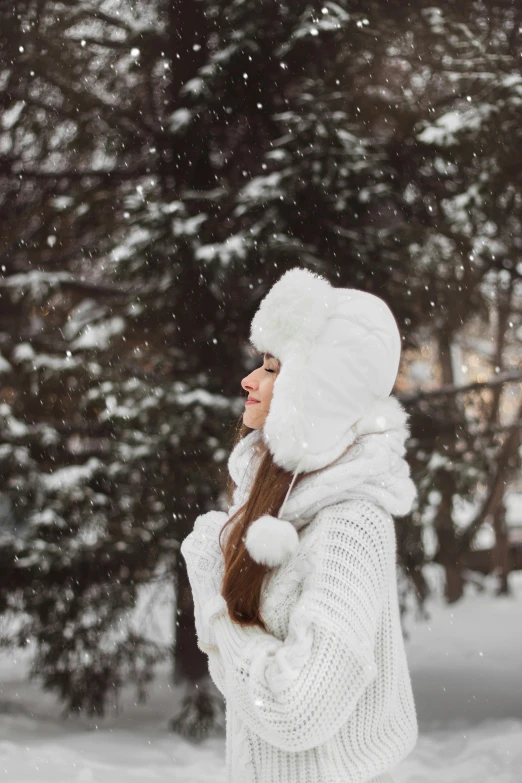 a woman in winter clothes holding her snowball