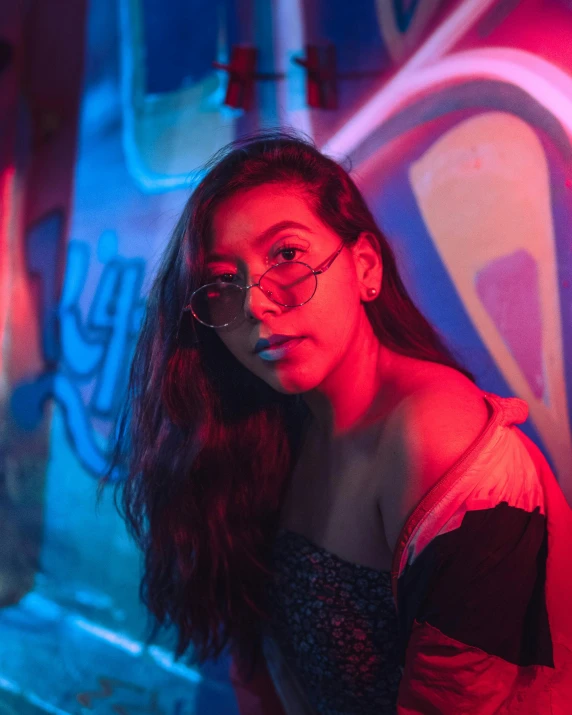 a young woman standing next to a wall