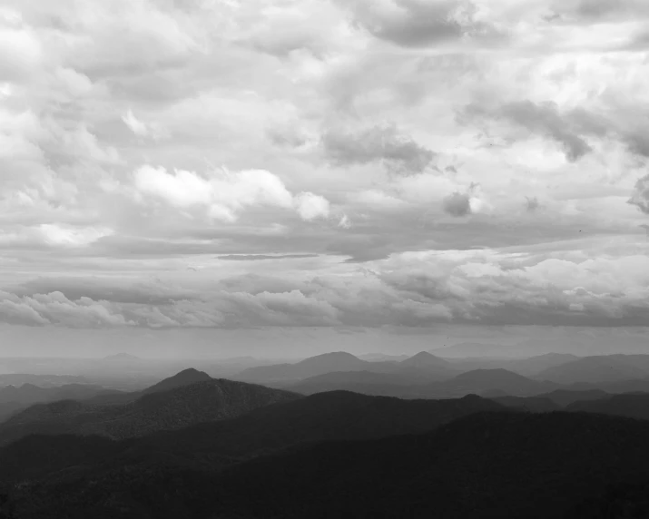 some mountains and a bunch of clouds on a cloudy day