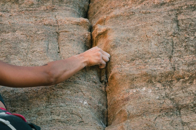 the person is climbing up on the rocks