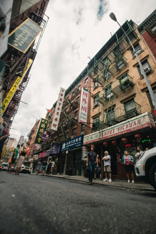 pedestrians walk down a street in front of a colorful building