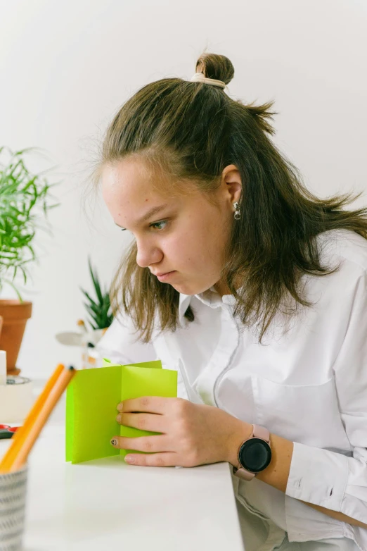 a girl with long hair holding a green folder