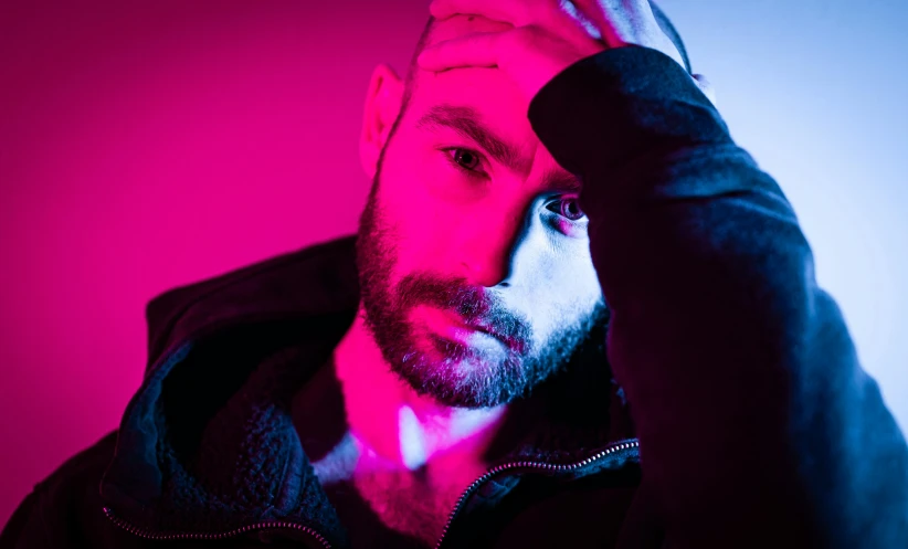 man is looking at camera in red and pink light