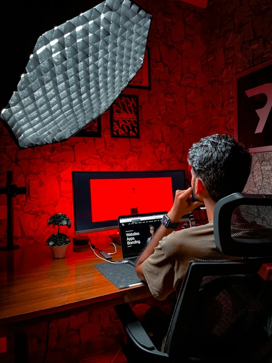 a man sitting at a desk on a cell phone