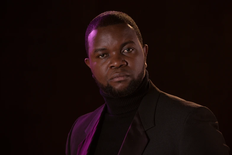 a man in a black suit and purple tie