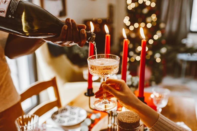 a person pouring champagne into a wine glass