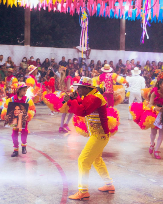 people dancing in brightly colored outfits at a show