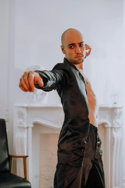 a man holding his fist while wearing leather clothing