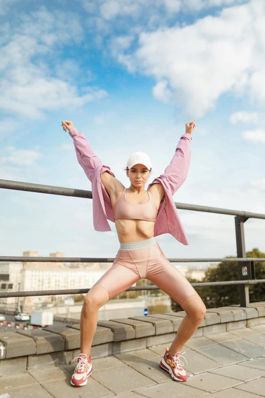 woman posing on street in sportswear and hat