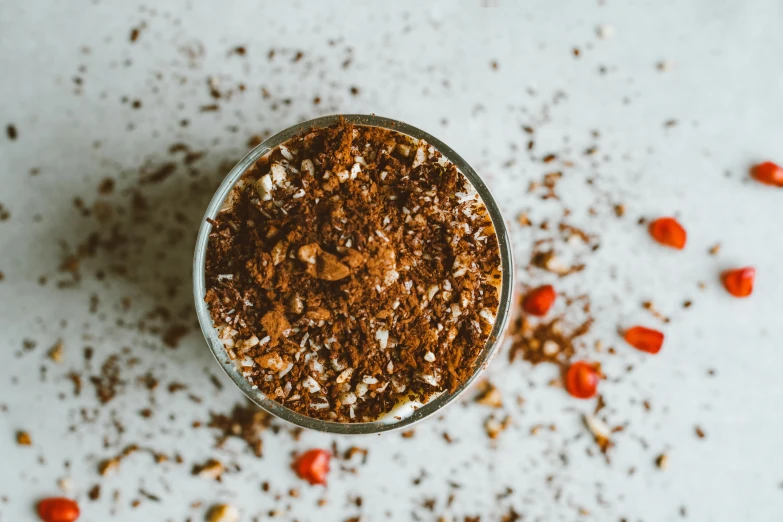 a cup with a variety of spices in it on a table