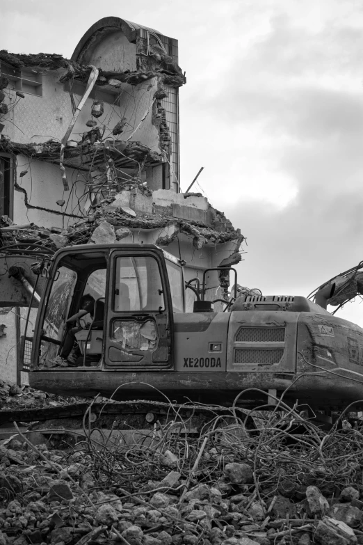 an old truck sits in the rubble beside a building