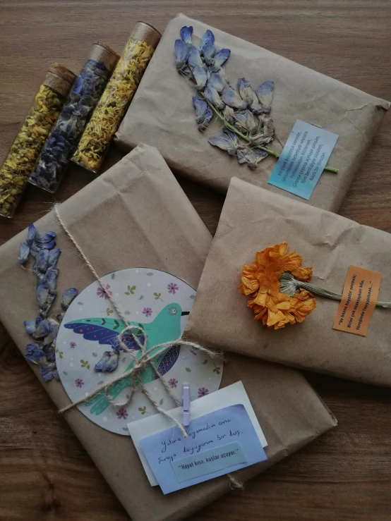 three gifts wrapped in brown paper and adorned with flowers