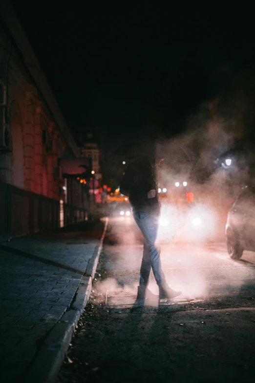 the man is standing on the side walk and smoking