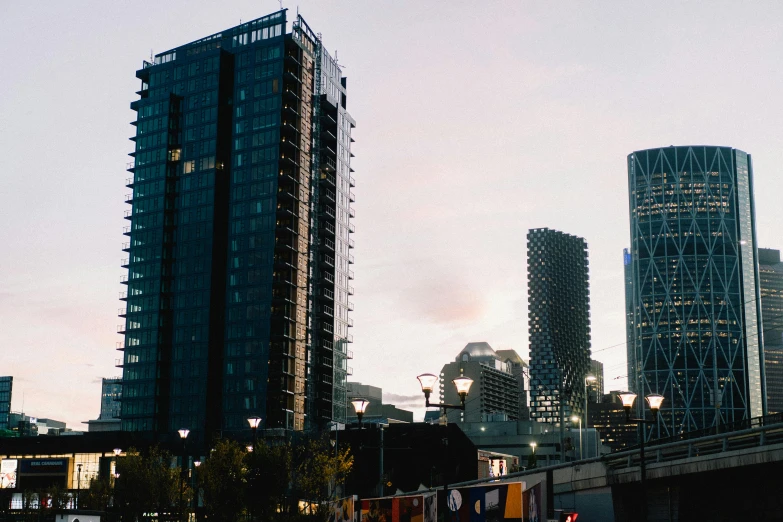 a very tall building near a bridge and a bunch of other buildings