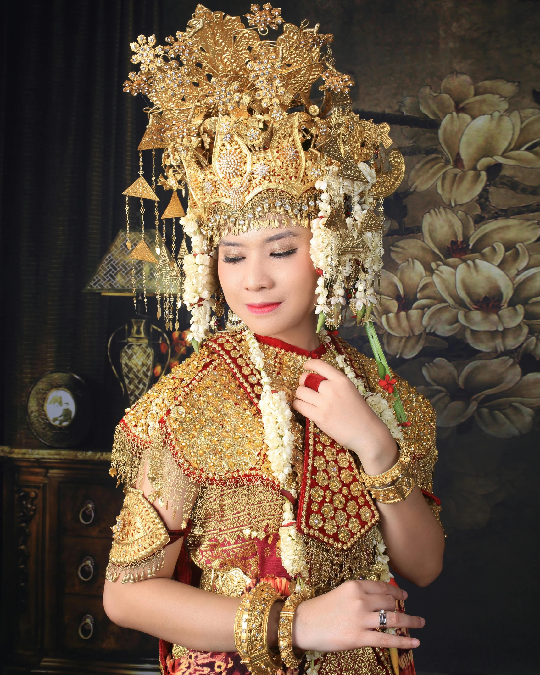 young woman dressed in thai garb, gold jewelry and gold celets
