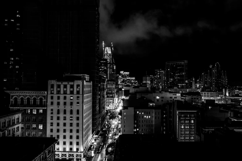 a city in black and white with buildings and cars at night