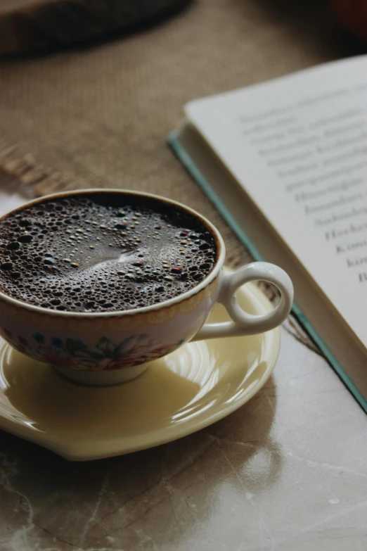 a  chocolate beverage in a cup sitting on a saucer