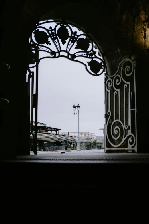 an iron gate entrance to a large empty field