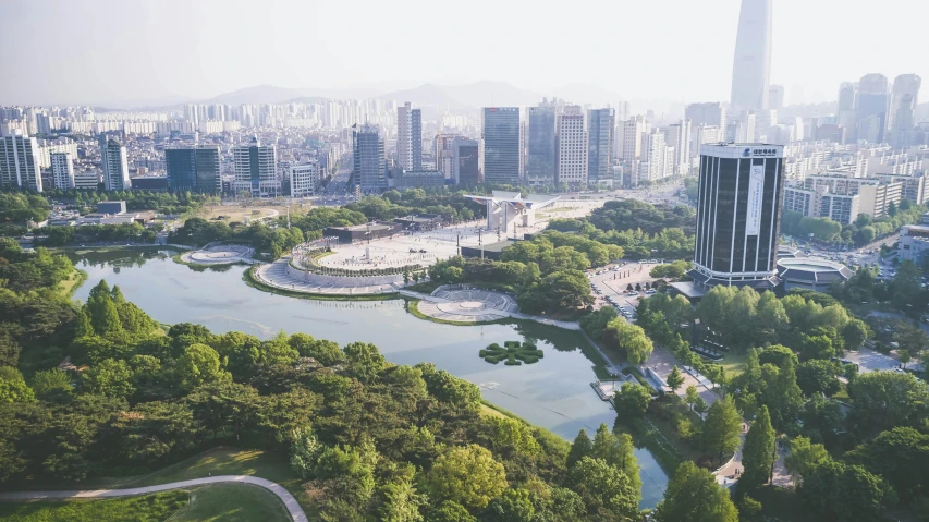 a city and a lake in a park next to a bunch of tall buildings