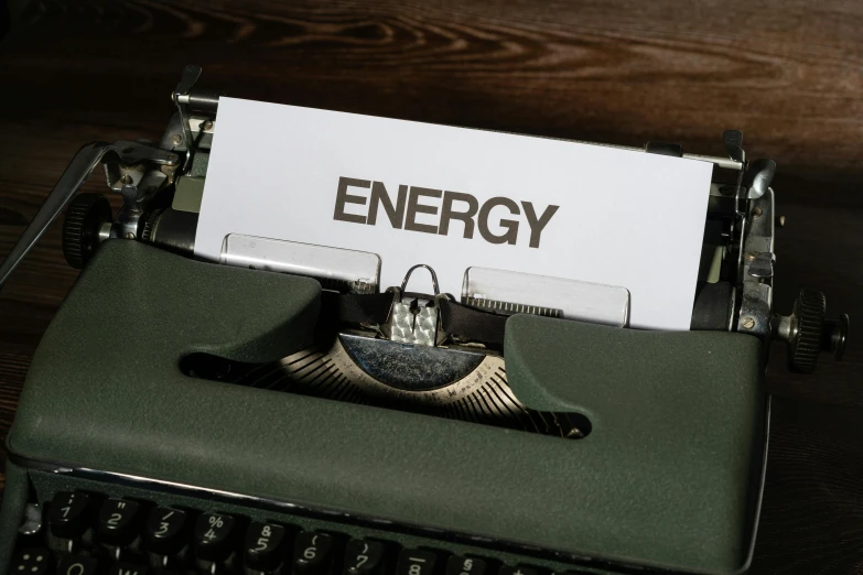 there is an empty sheet with the word energy on it next to an old typewriter