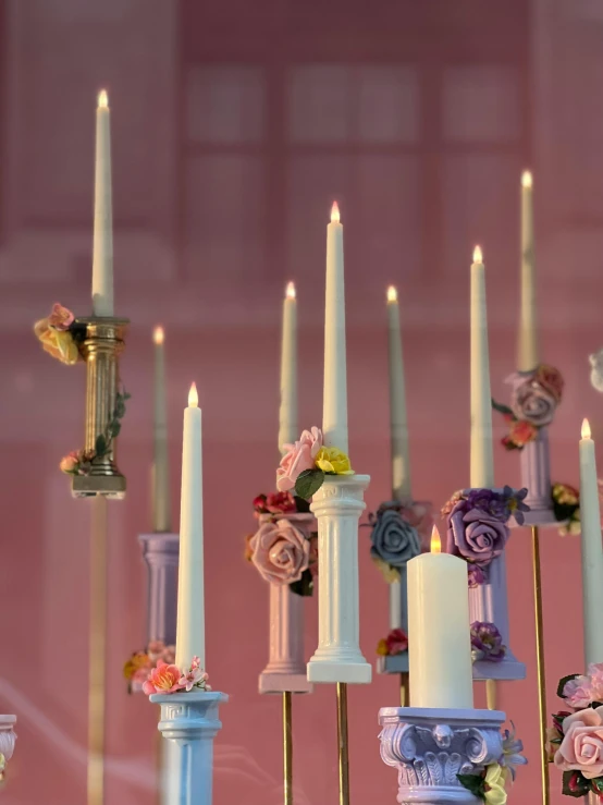 a bunch of candles with different colored flowers