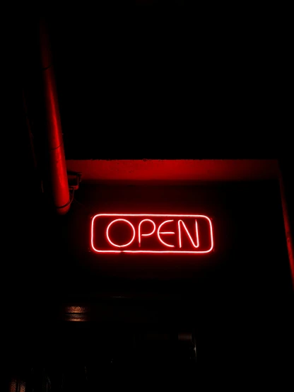 a red neon open sign is lit up