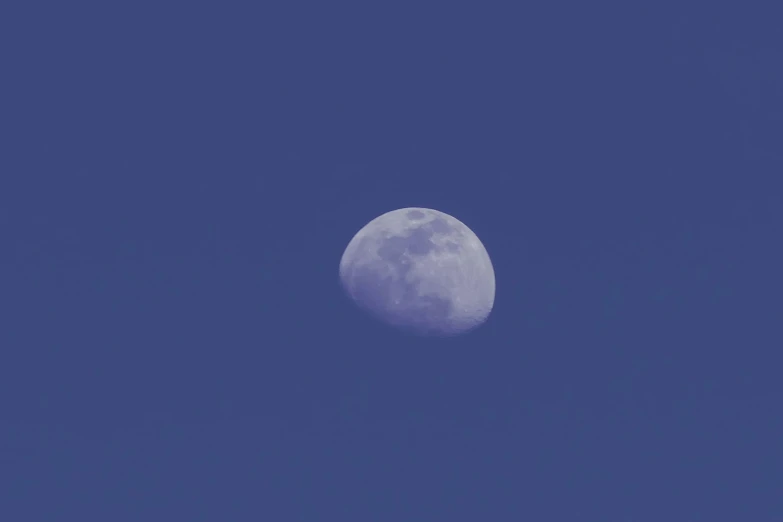 the moon is illuminated against a clear blue sky