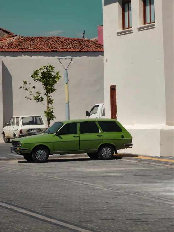 a green car parked on the side of the street