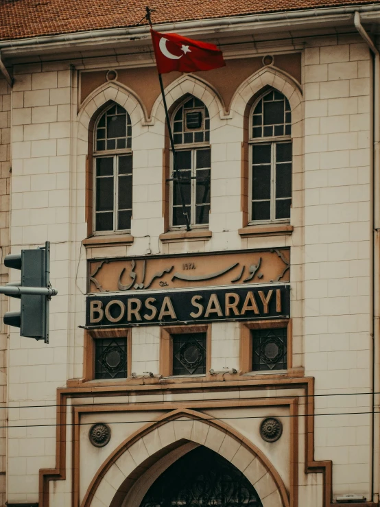 a white and tan building has a flag flying at the top