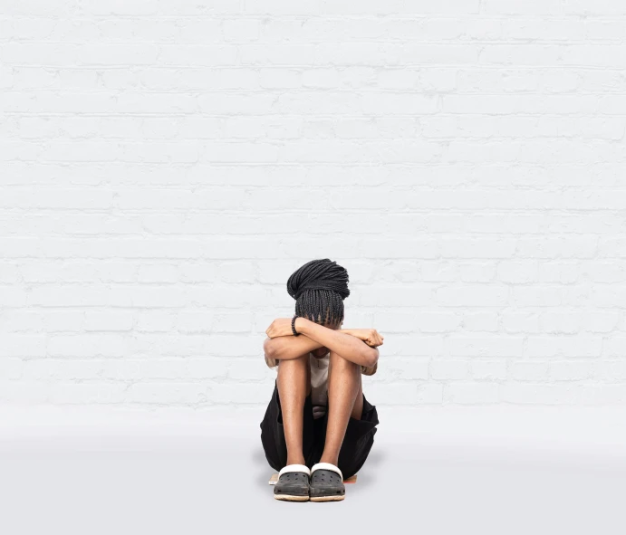 a boy sitting in the corner of a room