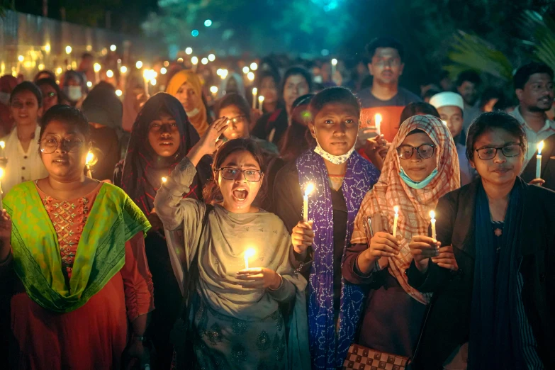 a group of women and men holding candles in their hands