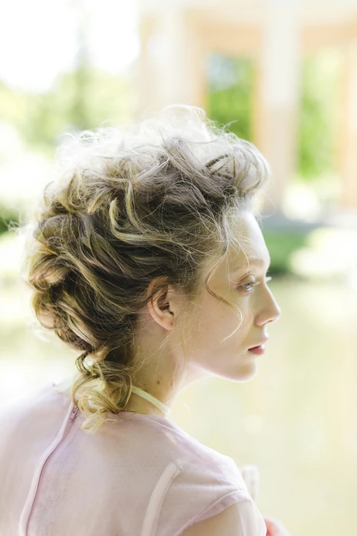 a woman with curly hair sitting next to water