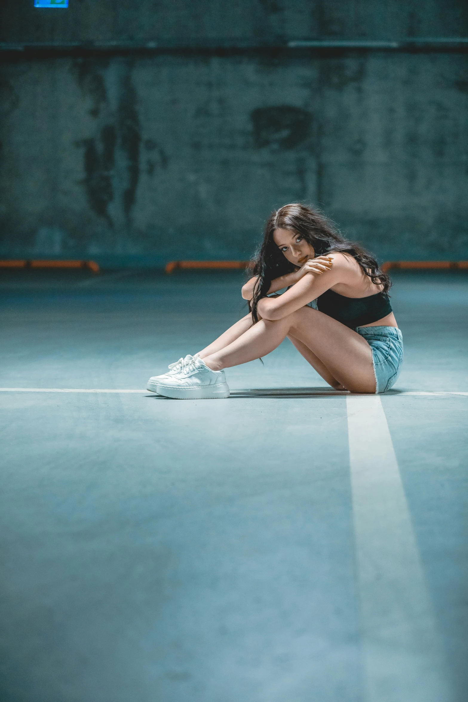 a woman sits on the ground looking down