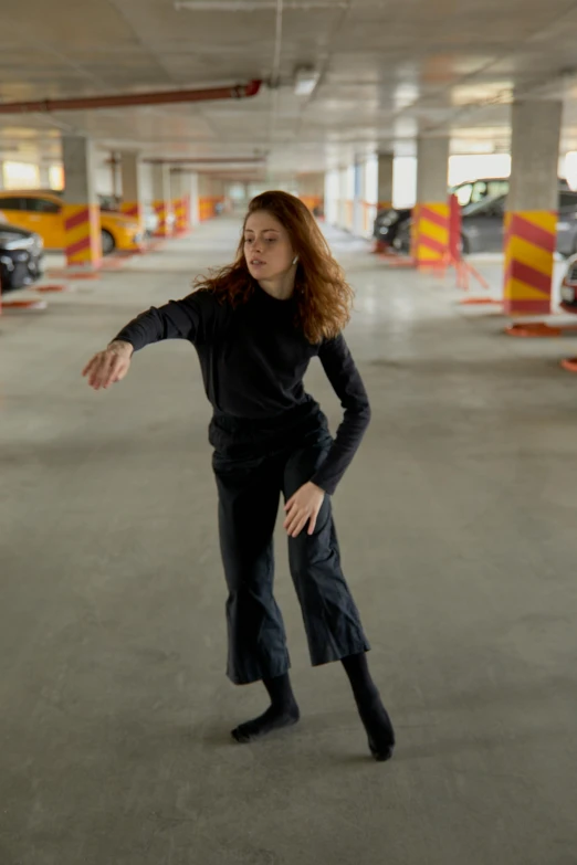 a woman in an orange parking garage about to throw a frisbee