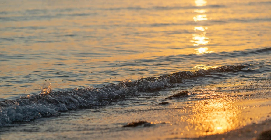 the light is shining on the water as seen from the beach