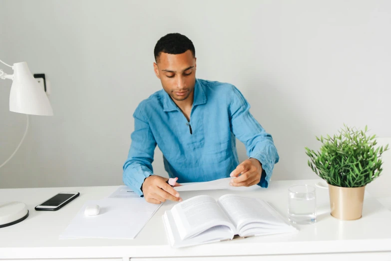 man sitting at a desk studying a book