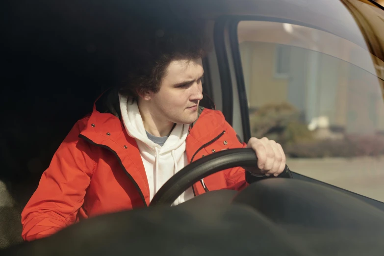 a man sitting in the drivers seat of a car with his head out the window