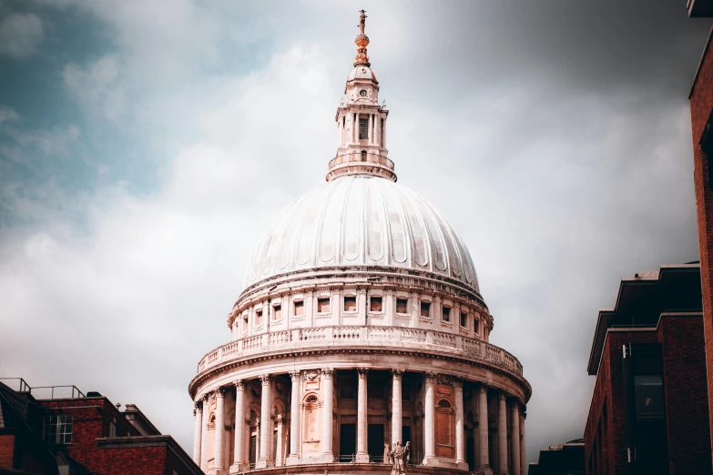 an old dome with a cloudy sky behind it