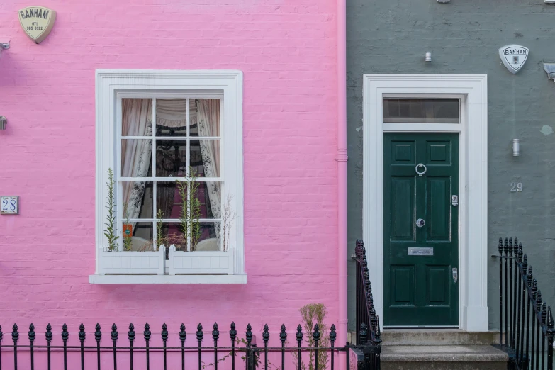 a pretty colorful house is painted pink, grey and white