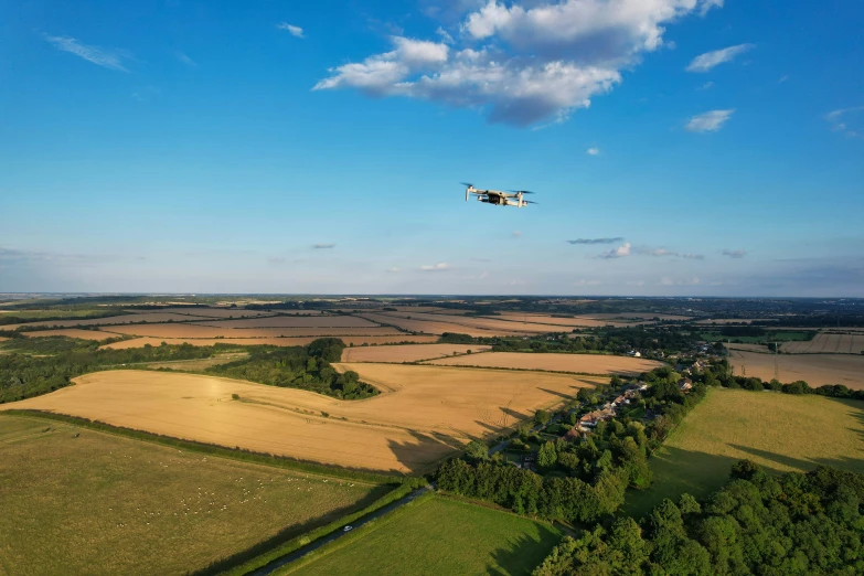 an airplane flies above farmlands and crops