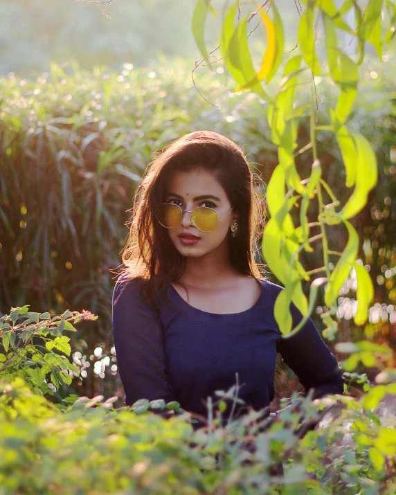 a beautiful young woman standing under green plants